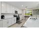 Bright kitchen features white cabinets, stainless steel appliances, and tile backsplash, offering modern style and functionality at 10805 Tarflower Dr # 101, Venice, FL 34293