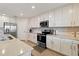Bright kitchen features white cabinets, stainless steel appliances, and tile backsplash, offering modern style and functionality at 10805 Tarflower Dr # 101, Venice, FL 34293