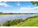 Scenic lake view featuring clear blue skies over a tranquil body of water and lush green shoreline at 10805 Tarflower Dr # 101, Venice, FL 34293