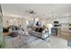 Spacious living area featuring modern sofas, a ceiling fan, and an open view to the kitchen and dining area at 10805 Tarflower Dr # 101, Venice, FL 34293