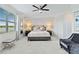 Bright main bedroom with a ceiling fan and bench seating in front of the bed at 10805 Tarflower Dr # 101, Venice, FL 34293