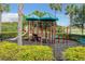 Community playground with slides, climbing structures, and protective fencing is surrounded by lush landscaping at 10805 Tarflower Dr # 101, Venice, FL 34293