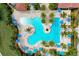 Aerial view of a luxurious community pool with palm trees, lounge chairs, umbrellas, and meticulously landscaped surroundings at 10805 Tarflower Dr # 101, Venice, FL 34293