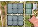 Aerial view of eight well-maintained tennis courts surrounded by lush landscaping in a quiet neighborhood at 10805 Tarflower Dr # 101, Venice, FL 34293