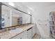 Bathroom with double sink vanity featuring granite countertops and large mirror at 12359 Deepwoods Ave, Port Charlotte, FL 33981