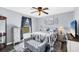 Comfortable bedroom featuring soft gray walls, a ceiling fan, and ample natural light through the window at 12359 Deepwoods Ave, Port Charlotte, FL 33981