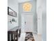 Bright and airy entryway with tiled floor, pendant light fixture, decorative console table and bicycle wall decor at 12359 Deepwoods Ave, Port Charlotte, FL 33981