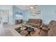 Light blue living room featuring a ceiling fan, a wall-mounted TV and beach themed wall decor at 12359 Deepwoods Ave, Port Charlotte, FL 33981
