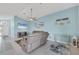 A spacious light blue living room featuring tile floors, ceiling fan, and comfortable seating arrangement at 12359 Deepwoods Ave, Port Charlotte, FL 33981