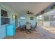 Inviting patio with a dining set, ceiling fan, and a retro mini-fridge, perfect for outdoor entertaining at 12359 Deepwoods Ave, Port Charlotte, FL 33981