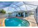 Enclosed pool area with brick decking, a covered dining area, and an access door at 12359 Deepwoods Ave, Port Charlotte, FL 33981