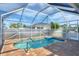 Enclosed pool area with a sparkling pool, brick-paver deck, and screen enclosure, offering a private outdoor oasis at 12359 Deepwoods Ave, Port Charlotte, FL 33981