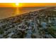 Aerial view of a charming coastal community at sunset, with one property highlighted, near a stunning beach at 1245 Gulf Blvd, Englewood, FL 34223