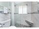 Bathroom showing tiled shower with glass door, corner seat, and window at 1245 Gulf Blvd, Englewood, FL 34223