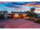 The home boasts vibrant orange exterior paint, enhanced by a colorful sunset sky, and lush tropical landscaping at 1245 Gulf Blvd, Englewood, FL 34223