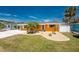 Charming single-story home with a well-manicured lawn and vibrant landscaping including palm trees at 1245 Gulf Blvd, Englewood, FL 34223