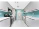 Galley kitchen features ample gray cabinetry, stainless steel appliances and a view of the backyard at 1245 Gulf Blvd, Englewood, FL 34223