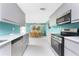 The kitchen showcases stainless steel appliances and sleek gray cabinets that connects to the dining room at 1245 Gulf Blvd, Englewood, FL 34223