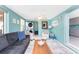Comfortable living room area featuring a modern sofa, bright windows, and a ceiling fan with washer and dryer at 1245 Gulf Blvd, Englewood, FL 34223