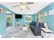 Comfortable living room area featuring a modern sofa, bright windows, and a ceiling fan at 1245 Gulf Blvd, Englewood, FL 34223