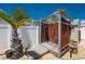 Outdoor shower with a wooden frame and platform, complemented by tropical landscaping and a gravel base at 1245 Gulf Blvd, Englewood, FL 34223