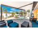 Outdoor patio featuring a pool, spa, entertainment area, and ample seating with mature tropical landscaping at 1245 Gulf Blvd, Englewood, FL 34223