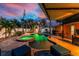Evening shot of the outdoor patio featuring a pool, spa, entertainment area, and ample seating with mature landscaping at 1245 Gulf Blvd, Englewood, FL 34223