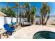 Close up of the landscaped pool area with blue chair and paver deck at 1245 Gulf Blvd, Englewood, FL 34223