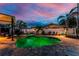 Backyard pool and spa illuminated at night with deck space and tropical landscaping at 1245 Gulf Blvd, Englewood, FL 34223