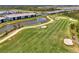 An aerial view of a golf course community with a swimming pool and clubhouse next to a pond at 12470 Wellen Golf St # 207, Venice, FL 34293