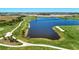 Scenic aerial view of the golf course, lake, and lush landscape creating a vibrant community at 12470 Wellen Golf St # 207, Venice, FL 34293