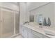 Elegant bathroom featuring a double vanity, large mirror, and a walk-in shower at 12470 Wellen Golf St # 207, Venice, FL 34293