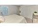 Bright bedroom featuring a large window and a comfortable bed with a white duvet, complemented by neutral-toned walls at 12470 Wellen Golf St # 207, Venice, FL 34293