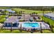 An aerial view shows a community pool complete with cabana, lounge chairs, and meticulously kept grounds with parking at 12470 Wellen Golf St # 207, Venice, FL 34293