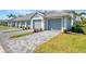 Beautiful townhome exterior showcasing the gray garage doors, paved driveway, well-maintained lawn, and a home number at 12470 Wellen Golf St # 207, Venice, FL 34293
