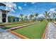Exterior view of bocce ball courts bordered by palm trees and lush landscaping at 12470 Wellen Golf St # 207, Venice, FL 34293