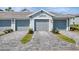 Attached garage with an interlocking brick paver driveway and manicured landscaping at 12470 Wellen Golf St # 207, Venice, FL 34293