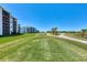 Lush golf course with modern condo buildings, offering an attractive residential view at 12470 Wellen Golf St # 207, Venice, FL 34293