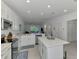 Open-concept kitchen with island, white cabinetry, and views into the living area at 12470 Wellen Golf St # 207, Venice, FL 34293