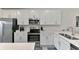 Modern white kitchen with stainless steel appliances and ample cabinet space at 12470 Wellen Golf St # 207, Venice, FL 34293
