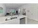 Kitchen island sink with dishwasher overlooks open floor plan and living room at 12470 Wellen Golf St # 207, Venice, FL 34293