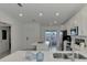 Open kitchen with white cabinetry, stainless steel appliances, island, and lots of natural light at 12470 Wellen Golf St # 207, Venice, FL 34293