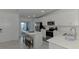 A modern kitchen with white cabinetry, an island, and stainless steel appliances at 12470 Wellen Golf St # 207, Venice, FL 34293