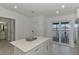 Bright kitchen island with white countertops and sliding glass doors to screened patio at 12470 Wellen Golf St # 207, Venice, FL 34293