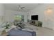 Bright living room featuring comfortable seating, stylish decor, and sliding glass doors at 12470 Wellen Golf St # 207, Venice, FL 34293