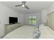 Bright main bedroom with golf course views, a dresser and contemporary ceiling fan at 12470 Wellen Golf St # 207, Venice, FL 34293