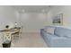 A modern office space features a work desk, chair, and sofa, with a painting adding a touch of color to the room at 12470 Wellen Golf St # 207, Venice, FL 34293