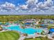 Beautiful community pool with aqua umbrellas, palm trees, sun loungers, and nearby tennis courts at 12470 Wellen Golf St # 207, Venice, FL 34293
