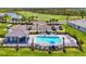 Community pool area featuring lounge chairs, umbrellas, an outdoor seating area and landscaped grounds at 12470 Wellen Golf St # 207, Venice, FL 34293
