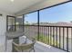View from screened balcony showing table, chairs, and view of surrounding roofs at 12470 Wellen Golf St # 208, Venice, FL 34293